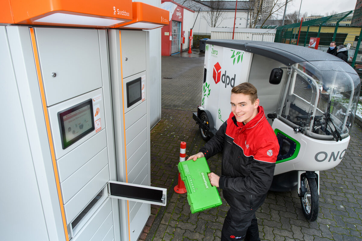 Delivery worker swapping a battery at a Swobbee station
